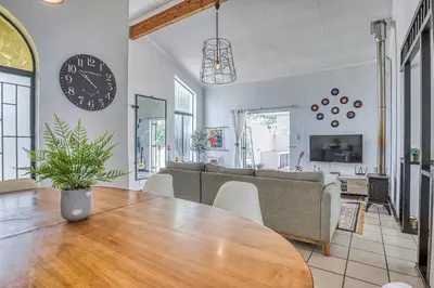 a living room with a table and a couch at Modern Spanish House-3br-pool-solar-samrand in Centurion