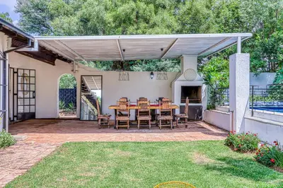a patio with a wooden table and chairs at Modern Spanish House-3br-pool-solar-samrand in Centurion