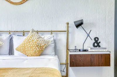 a bed with white pillows and a lamp on a table at Modern Spanish House-3br-pool-solar-samrand in Centurion