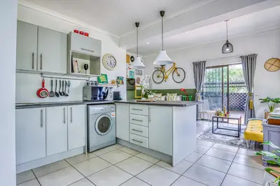 a kitchen with white cabinets and a washing machine at Chic Midtown Studio-1 Bed-solar-pool-fibre-samrand in Centurion