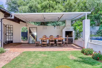 a patio with a wooden table and chairs at Chic Midtown Studio-1 Bed-solar-pool-fibre-samrand in Centurion