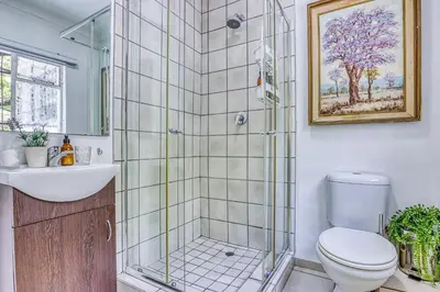 a bathroom with a shower and a toilet and a sink at Chic Midtown Studio-1 Bed-solar-pool-fibre-samrand in Centurion