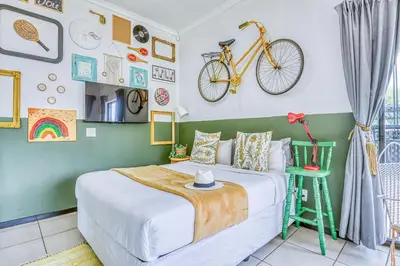 a bedroom with a bed and a bike on the wall at Chic Midtown Studio-1 Bed-solar-pool-fibre-samrand in Centurion