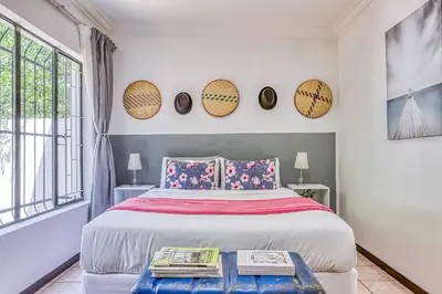 a bedroom with a bed and a large window at The Cottage-1 Bed-pool-bbq-fibre-solar-samrand in Centurion