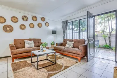 a living room with two couches and a table at The Cottage-1 Bed-pool-bbq-fibre-solar-samrand in Centurion