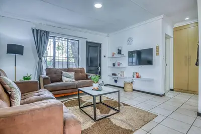 a living room with a couch and a table at The Cottage-1 Bed-pool-bbq-fibre-solar-samrand in Centurion