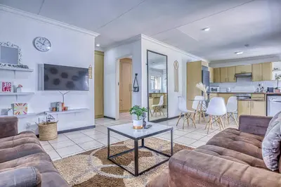 a living room with a couch and a table at The Cottage-1 Bed-pool-bbq-fibre-solar-samrand in Centurion