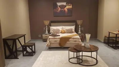 a bedroom with a bed with two tables and two tables sidx sidx sidx at South Gate Lodge in Polokwane