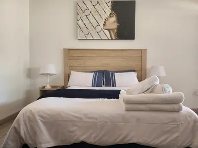 a bedroom with a bed with towels on it at South Gate Lodge in Polokwane