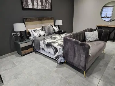 a bedroom with a bed and a couch at South Gate Lodge in Polokwane