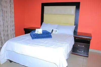 a bedroom with a white bed with two boxes on it at ZWIZWO Guest House in Thohoyandou