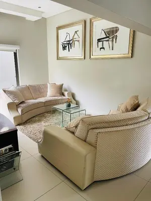 a living room with two couches and a table at Lulanipho Abode in Hartbeespoort