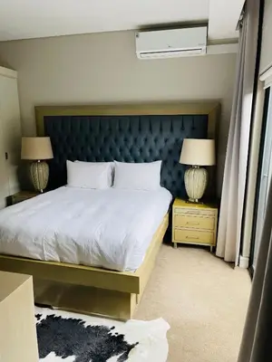 a bedroom with a large bed and two lamps at Lulanipho Abode in Hartbeespoort