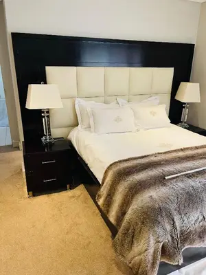a bedroom with a large bed with two lamps at Lulanipho Abode in Hartbeespoort