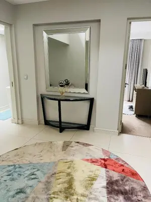 a room with a table and a large mirror at Lulanipho Abode in Hartbeespoort
