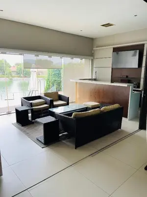 a living room with couches and a kitchen at Lulanipho Abode in Hartbeespoort