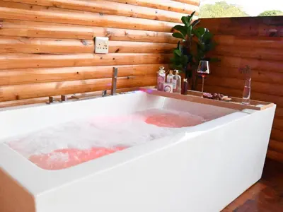 a large bath tub with a sink in a room at Ndi Musanda @ Nandoni in Vendaland