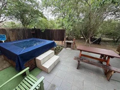 a patio with a hot tub and a picnic table at Babushka in Marloth Park