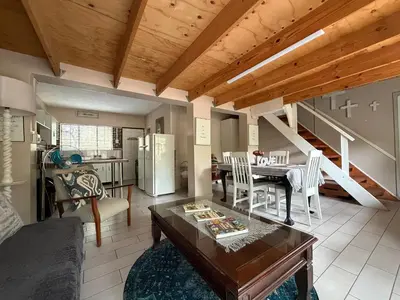 a kitchen and living room with a table and a dining room at Babushka in Marloth Park