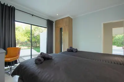 a bedroom with a large bed and a large window at Maroela Safari House in Marloth Park