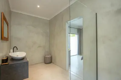 a bathroom with a sink and a glass shower at Maroela Safari House in Marloth Park