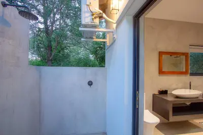 a bathroom with a sink and a toilet and a window at Maroela Safari House in Marloth Park