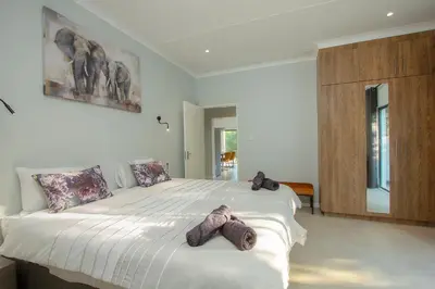 a bedroom with a large bed with stuffed animals on it at Maroela Safari House in Marloth Park