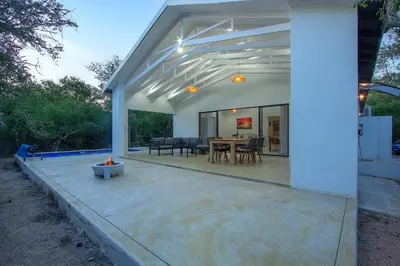 a patio with a table and chairs on it at Maroela Safari House in Marloth Park