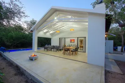 a house with a patio with a table and chairs at Maroela Safari House in Marloth Park