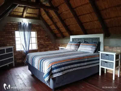 a bedroom with a large bed in a brick wall at Indlovu Inn in Marloth Park