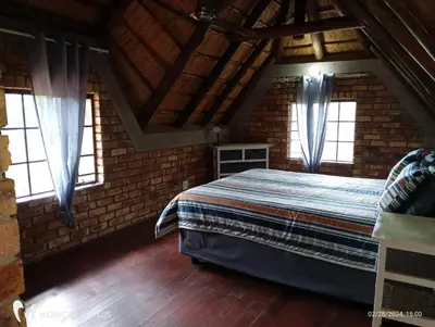 a bedroom with a bed in a brick wall at Indlovu Inn in Marloth Park
