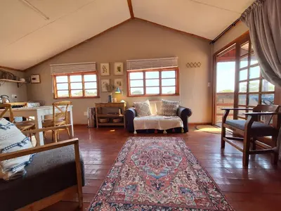 a living room with a couch and a table at Nyala Bush Cabin in Polokwane