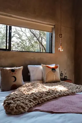 a bedroom with a large bed with a large window at Shongololo Bush Villa in Marloth Park