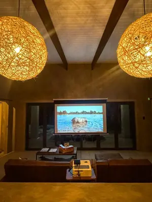 a living room with a flat screen tv and two lights at Shongololo Bush Villa in Marloth Park