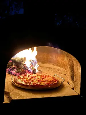 a pizza is being cooked in a pizza oven at Shongololo Bush Villa in Marloth Park