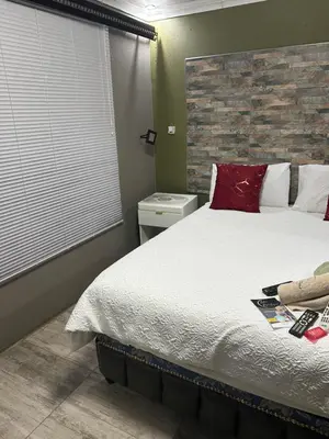 a bedroom with a large bed with red pillows at Lake Boutique Hotel in Thohoyandou