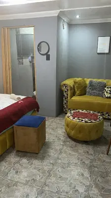 a living room with a bed and a couch at Lake Boutique Hotel in Thohoyandou