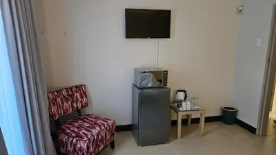 a room with a tv and a chair and a table at Grobler's Haven in Pretoria
