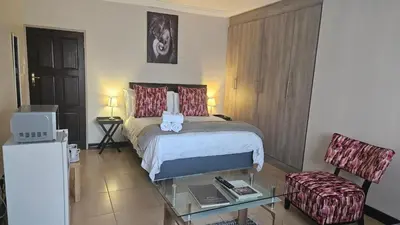 a hotel room with a bed and a glass table at Grobler's Haven in Pretoria