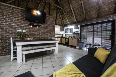 a living room with a tv on a brick wall at The Guest Villa in Benoni