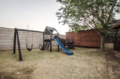 a playground with a slide in a yard at The Guest Villa in Benoni