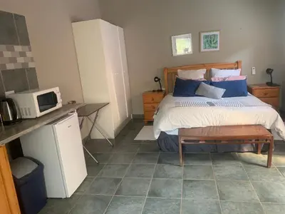 a bedroom with a bed with a microwave and a table at MAM in Mokopane