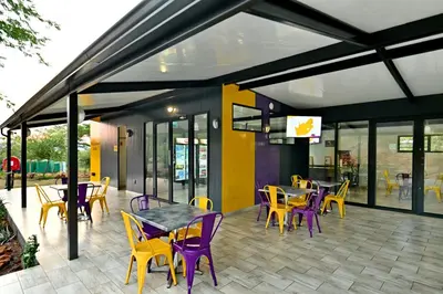a restaurant with purple chairs and tables on a patio at SleepOver Punda Maria Gate in Punda Maria