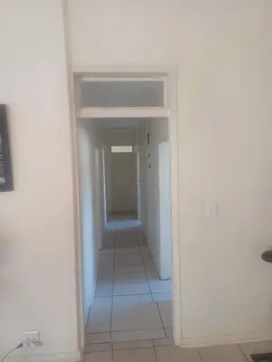 a hallway with a white wall and a white floor at Kempton Park Lodge Birch Acres Kempton Park in Kempton Park
