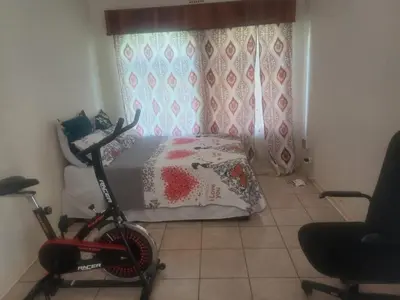 a bedroom with a bed and a bike in a room at Kempton Park Lodge Birch Acres Kempton Park in Kempton Park