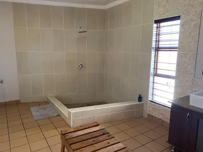 a bath tub in a bathroom with a window at Waterkloof Glen Guest House in Pretoria