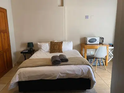 a bedroom with a bed with two slippers on it at Waterkloof Glen Guest House in Pretoria