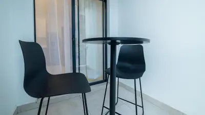 a black table and two chairs in front of a window at Chic Modern Midrand Escape in Midrand