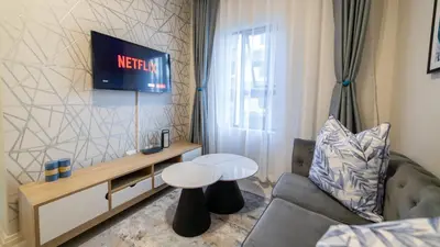 a living room with a couch and a tv at Chic Modern Midrand Escape in Midrand