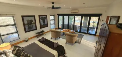 a living room with a couch and a table at Luxury GuesthouseCo RiverHouse in Marloth Park